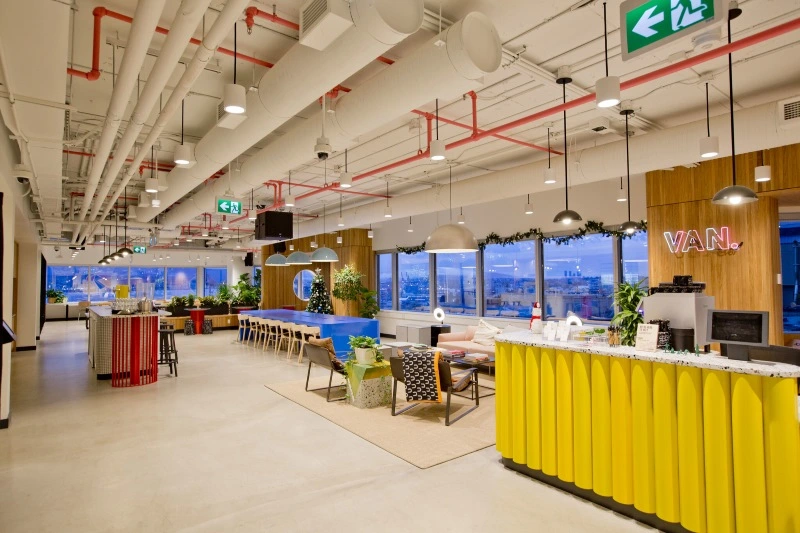 Spacious and vibrant WeWork office space in Vancouver, featuring modern design with communal desks and cozy lounge areas.